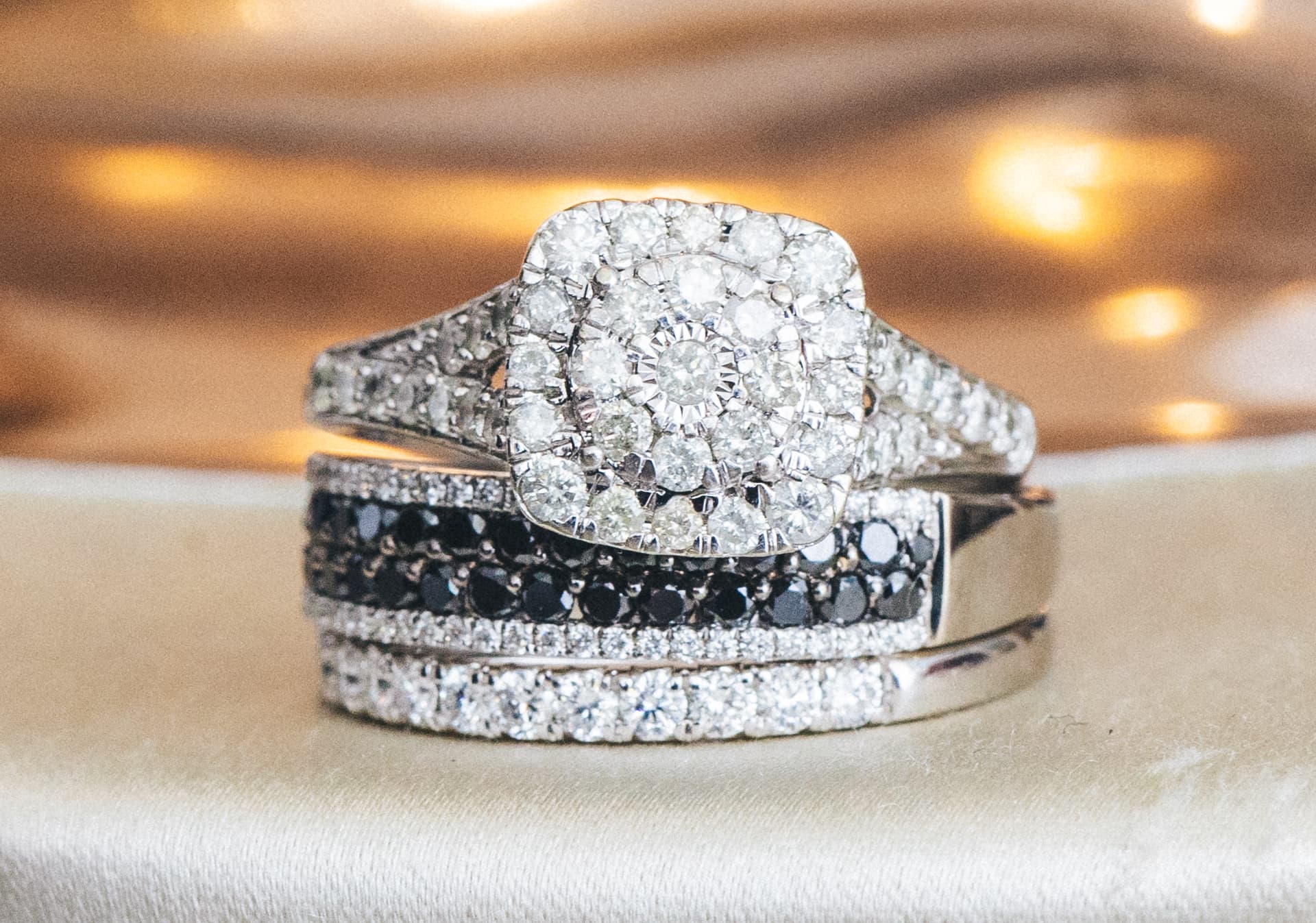 Engagement ring and two diamond bands resting on ivory fabric