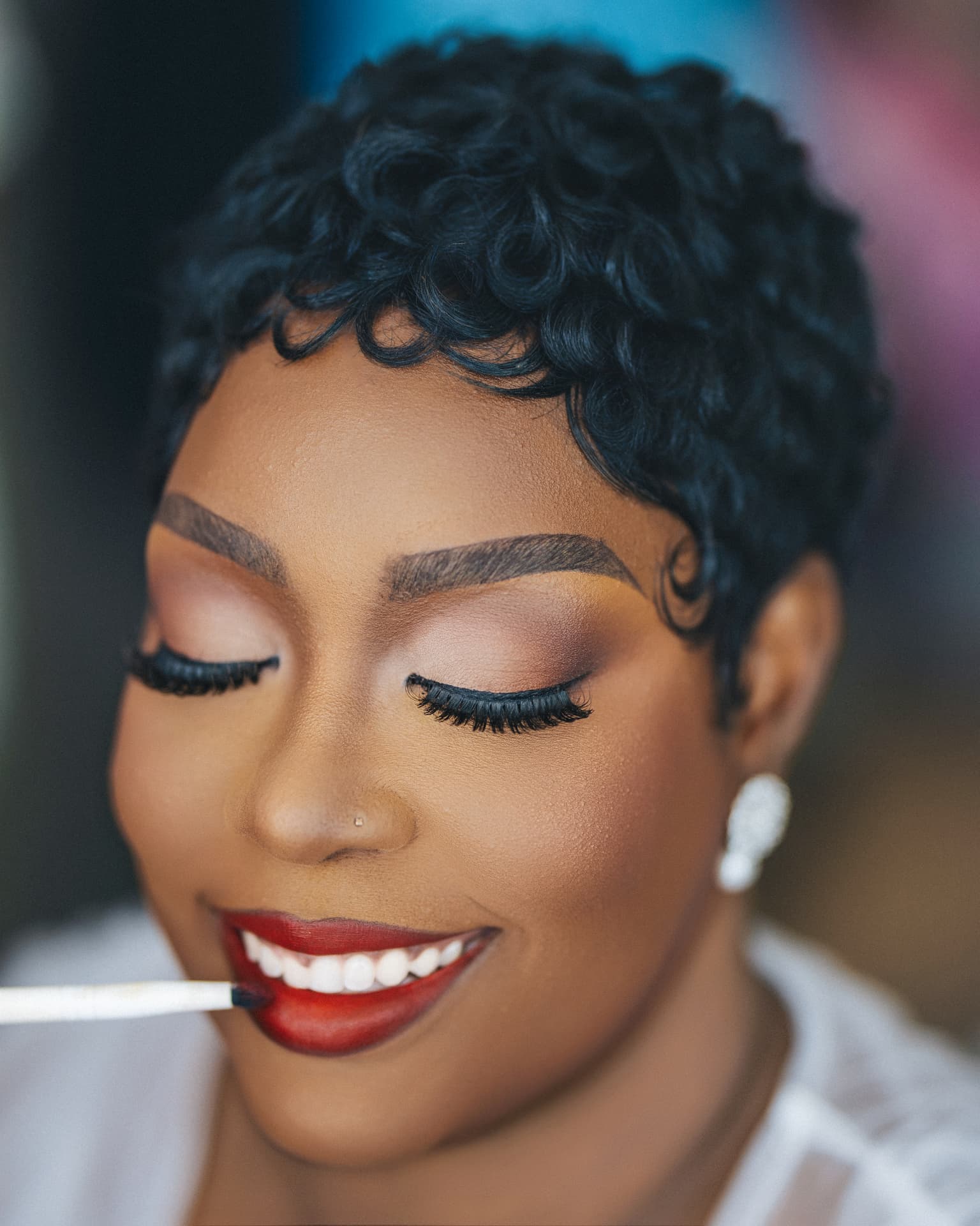 Makeup artist finishing the bride's red lip