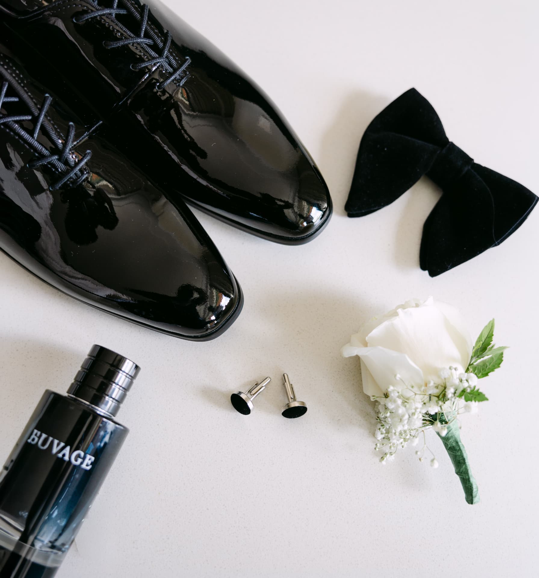 Patent dress shoes, velvet bow tie, cufflinks, cologne, and a white rose boutonnière