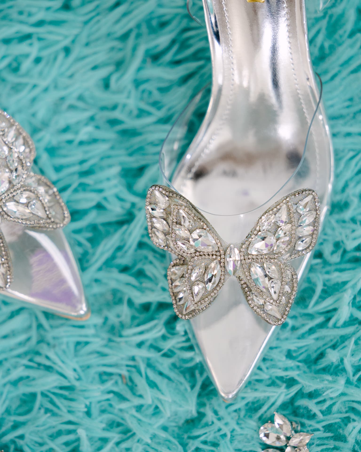 Crystal butterfly bridal heels on a teal textured surface